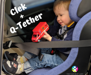 Clek Q-Tether with a toddler rear-facing in the car seat playing with a red truck